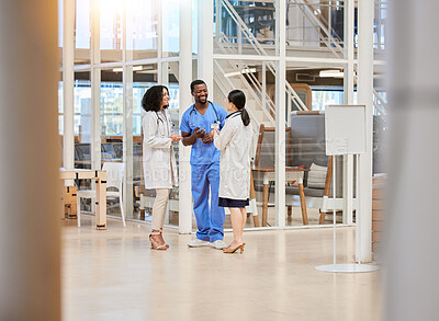 Buy stock photo Group of doctors, nurses and people talking in hospital lobby, discussion and communication. Team, medical professional and happy black man and women smile in conversation, chat or healthcare meeting