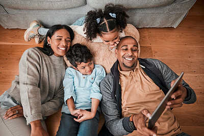 Buy stock photo Happy family, children and parents on tablet for selfie, video or movie streaming on internet subscription on living room floor. Home, relax and mom, dad and interracial kids with digital technology