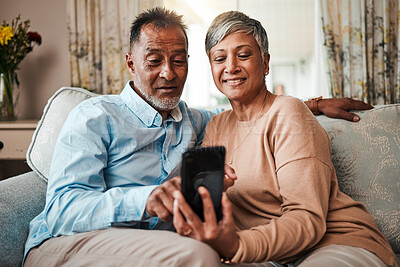 Buy stock photo Senior couple, phone and reading on home sofa with internet connection, network and love. Mature man and woman relax together on a couch with smartphone for streaming and online news or social media