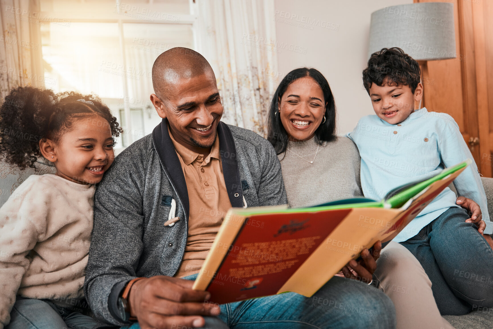 Buy stock photo Happy, love and family reading a book together in the living room for bonding in their house. Happiness, smile and parents enjoying a novel or story with their children on sofa in the lounge at home.