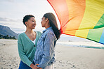 Gay, flag and lesbian couple at the beach for travel, freedom and bond, care and happy in nature together. Rainbow, love and women on ocean vacation embrace lgbt, partner or pride, date or acceptance