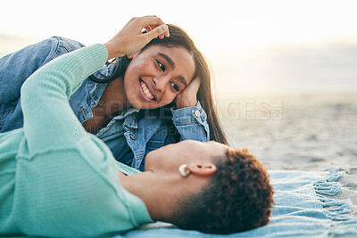 Buy stock photo Love, beach and lesbian couple lying on blanket together, embrace on sand and sunset holiday adventure. Lgbt women, bonding and relax on ocean vacation with romance, pride and happy picnic in nature.