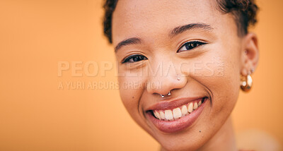 Buy stock photo Happy, woman and face closeup in studio with smile and confidence feeling cute. Orange background, young portrait and African female person with trendy, piercing and student fashion with gen z glow