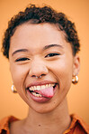 Happy, woman and tongue out portrait in studio with smile and confidence feeling silly . Orange background, young and African female person with trendy, modern and student fashion with gen z piercing