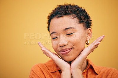 Buy stock photo Happy, woman relax and hands on face in studio with smile and confidence feeling cute. Orange background, young and African female person with trendy, modern and student fashion with mockup space