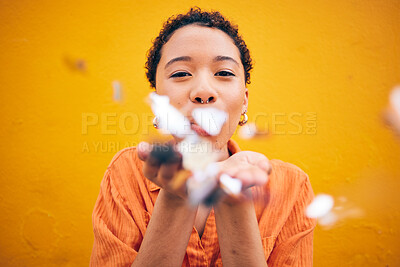 Buy stock photo Flowers, petals and portrait of woman on orange background for natural beauty, skincare and romance. Blowing, happy and female person with floral confetti for cosmetics, makeup and wellness in studio