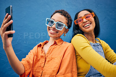 Buy stock photo Selfie, fashion and women in city with phone for social media, internet post and profile picture. Friends, influencer and female people relax in urban town with trendy sunglasses on blue background