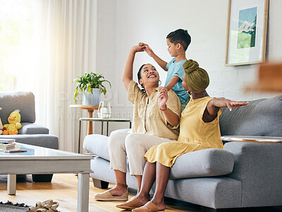 Buy stock photo Family, lesbian couple and boy child on a sofa with airplane, game and fun in their home together. Love, lgbt and women mother in a living room with foster kid and piggyback, bond and play in house