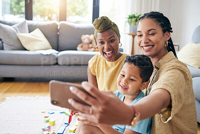 Buy stock photo Lesbian, women and son in family selfie, smile or care with toys, post or web blog on floor in home living room. Mother, male kid and happy for love, bonding or memory for social network app in house