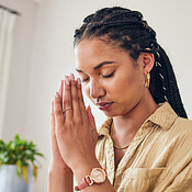 Hands, worship and woman praying in her living room for hope, help or ...