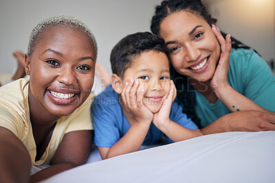 Buy stock photo Selfie, gay family and happy on a bed in home bedroom for security, quality time and love. Adoption, lesbian or LGBTQ women or interracial parents and happy kid together for social media memory