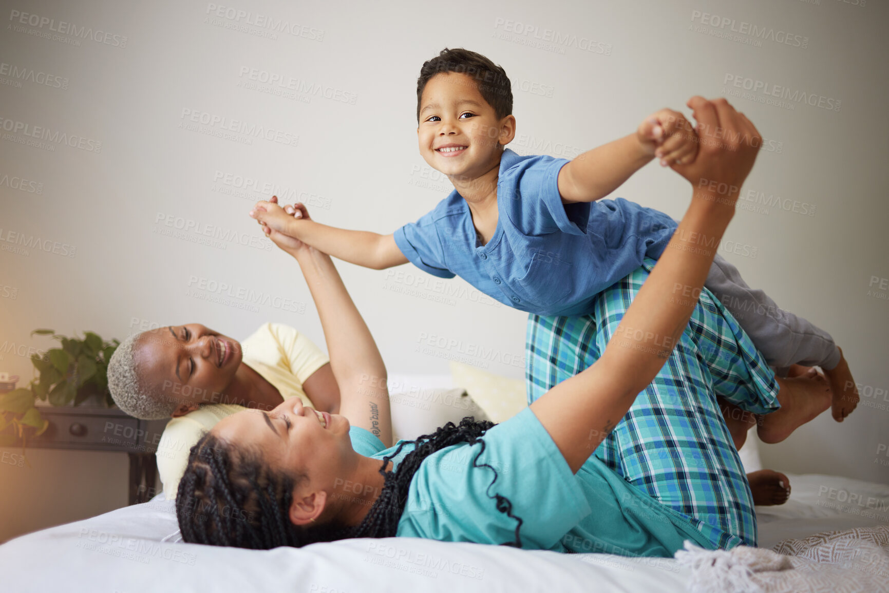 Buy stock photo Gay family, playing and child on a bed in a home bedroom for security, quality time and love. Adoption, lesbian or LGBTQ women or interracial parents lift a happy kid with fun game and support