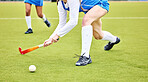 Hockey, closeup and female athlete playing a game, match or tournament on an outdoor field. Fitness, sports and young woman training or practicing a defence strategy with a stick and ball at stadium.