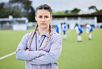 Woman coach, arms crossed and field for sports, hockey and portrait for teaching, fitness and exercise. Girl, serious face and guide for development, leadership and training for competition on grass
