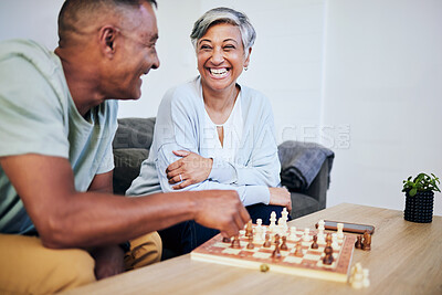 Buy stock photo Senior couple, playing chess and home for thinking, strategy or mindset with excited smile, relax or bonding. Elderly woman, man and sofa for board game, ideas or brainstorming for challenge in house