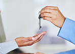 People, hands and realtor giving keys to new home for mortgage loan, property sale or investment. Closeup of woman customer and real estate agent for house payment, purchase or agreement in deal