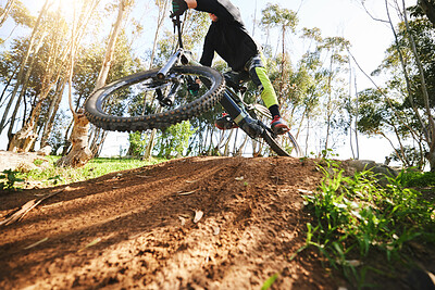 Buy stock photo Bike, jump and dirt with speed in low angle for sports, race and adventure in summer, woods or nature. Extreme cycling, person and outdoor for trail, competition or challenge for fitness in forest