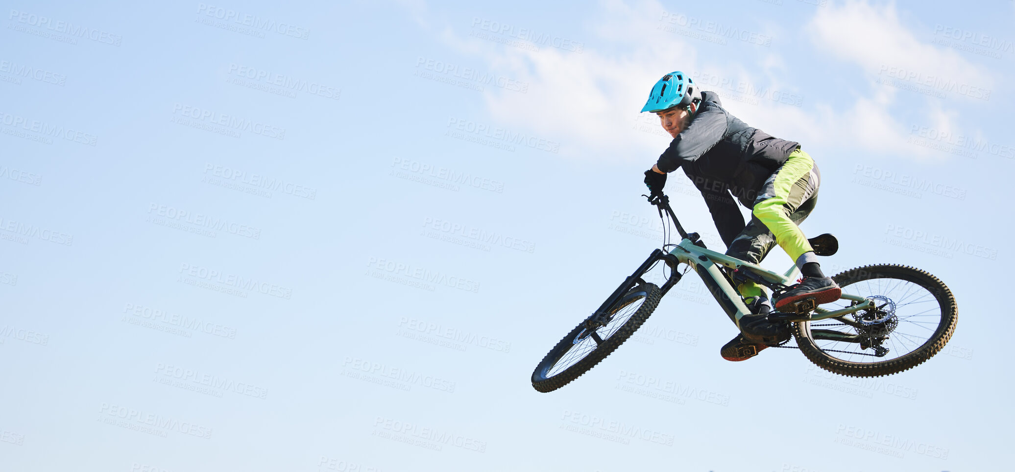 Buy stock photo Mountain bike, man and jump in blue sky for competition, freedom or adventure on mockup space. Banner of athlete, sports and bicycle in air for action, cardio race and courage of stunt, speed or risk