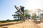 Bicycle, wheelie and man with ramp, outdoor and speed for sport, race or adventure in summer, fitness or nature. Extreme cycling, person and jump for trail, exercise or challenge for workout in dirt