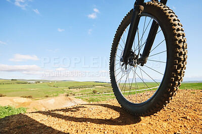 Buy stock photo Cycling, sports and closeup of wheel on bicycle for adrenaline on adventure, freedom and speed. Mountain bike, nature view and cyclist for training, exercise and fitness on dirt road, trail or track
