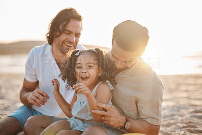 Buy stock photo Gay father, family and girl at beach with love, smile and hug for vacation, laugh and outdoor on sand in sunset. LGBTQ men, young kid and adoption with parents, holiday and comic tickling in summer