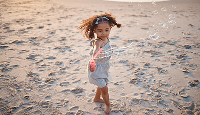 Buy stock photo Girl kid, beach and outdoor with bubbles, playing and freedom with air, games and smile in nature. Young female child, soap and water with plastic toys in wind, summer sunshine and happy on vacation