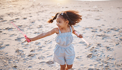 Buy stock photo Girl child, beach and outdoor with bubbles, playing and freedom on sand, games and smile in nature. Young female kid, soap and water with plastic toys in wind, summer sunshine and happy on vacation