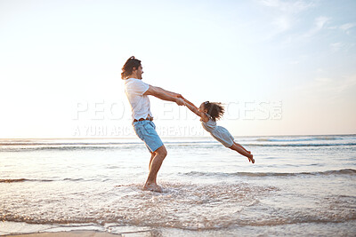 Buy stock photo Father, spin girl child and beach with games, holding hands or happy for bonding together by waves. Dad, female kid and swing with love, care and playing by sea, ocean or family on vacation in summer