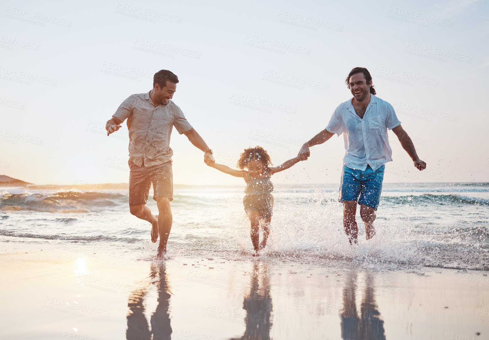 Buy stock photo Holding hands, beach and gay couple with a child, happy or vacation with celebration, quality time or bonding. Queer people, men or kid with sun flare, seaside holiday or family with love or lgbtq