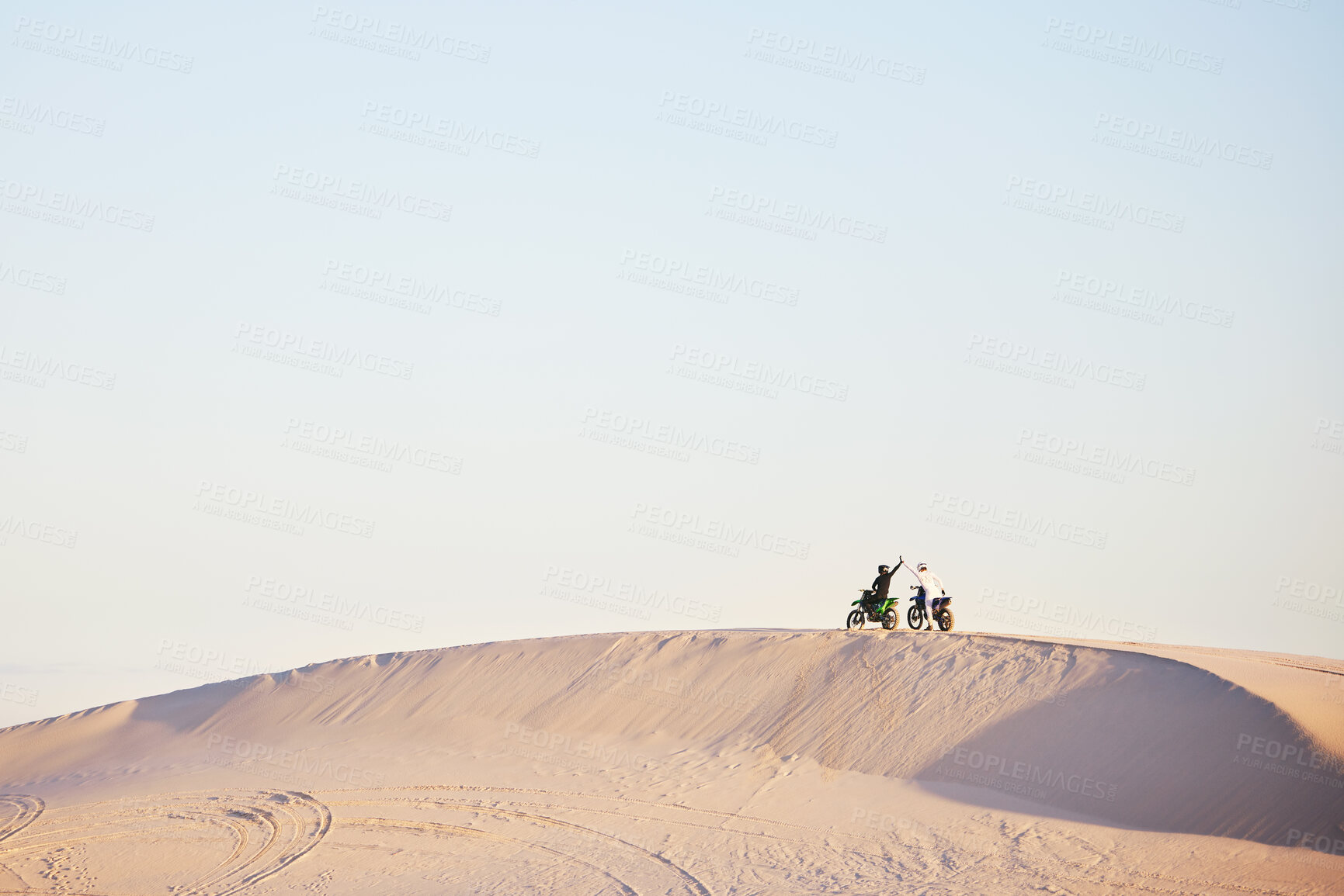 Buy stock photo Desert blue sky, motorbike and sports people high five, excited celebrate travel, teamwork or off road achievement. Motorcycle adventure, mockup winner or athlete driver collaboration on sand dunes