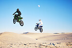 Motorcycle, desert and jump in sky, speed and competition at  outdoor race for performance, goal or off road. Motorbike athlete, dune and ramp in nature, sand or together for training in mockup space