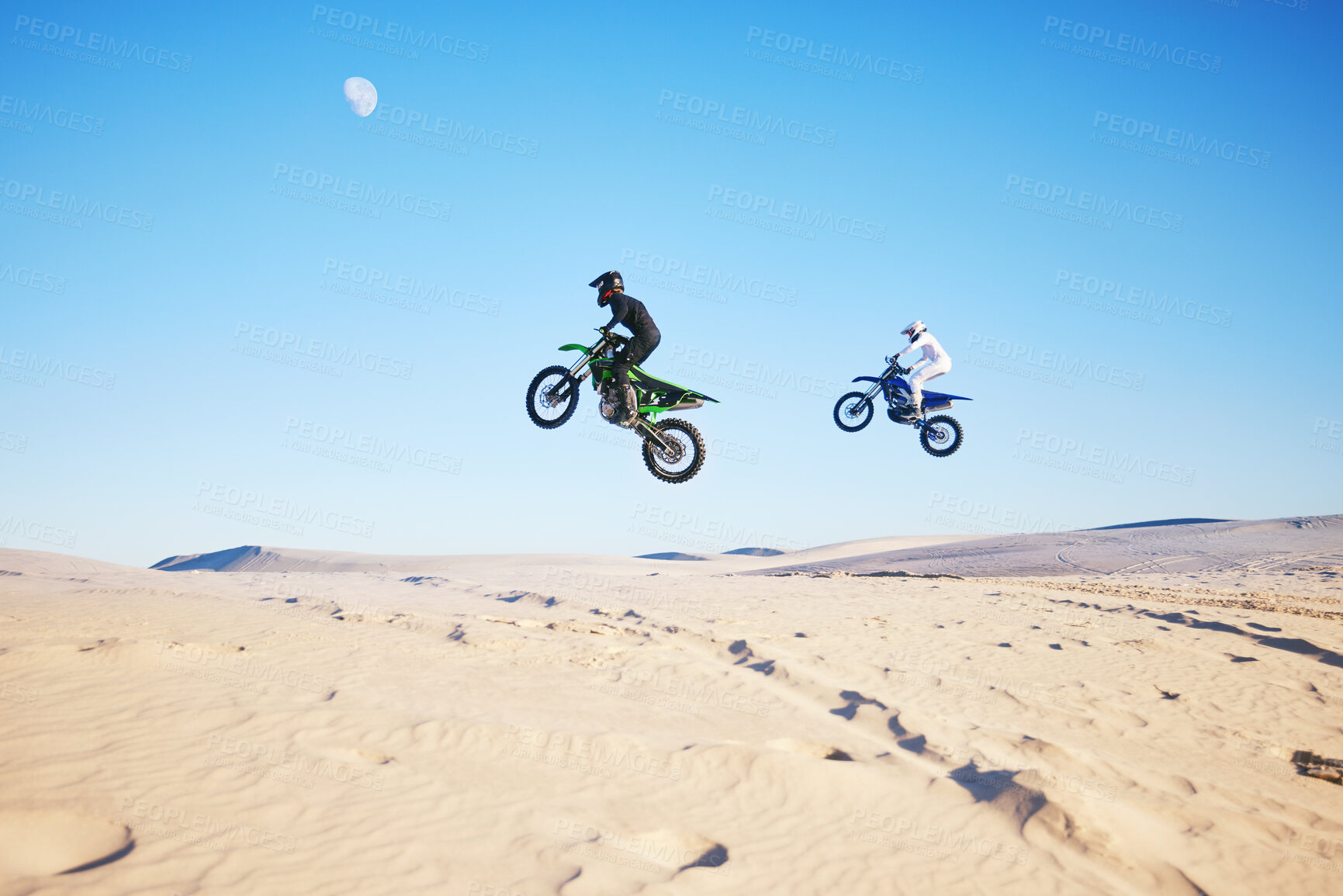 Buy stock photo Motorbike, desert race and jump in air for competition, stunt and outdoor for performance, goal and speed. Motorcycle athlete, dunes and ramp in nature, fast or together for contest by sky background