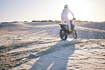 Desert, motorbike and back of sports person travel, transport and driving on challenge adventure, freedom and training. Nature sunset, extreme action and athlete ride motorcycle on sand dunes hill