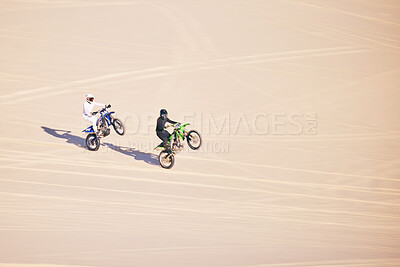 Buy stock photo Motorcycle, sand and sports with people in the desert for adrenaline, adventure or training in nature. Bike, summer and freedom with friends outdoor together to wheelie while riding on mockup space