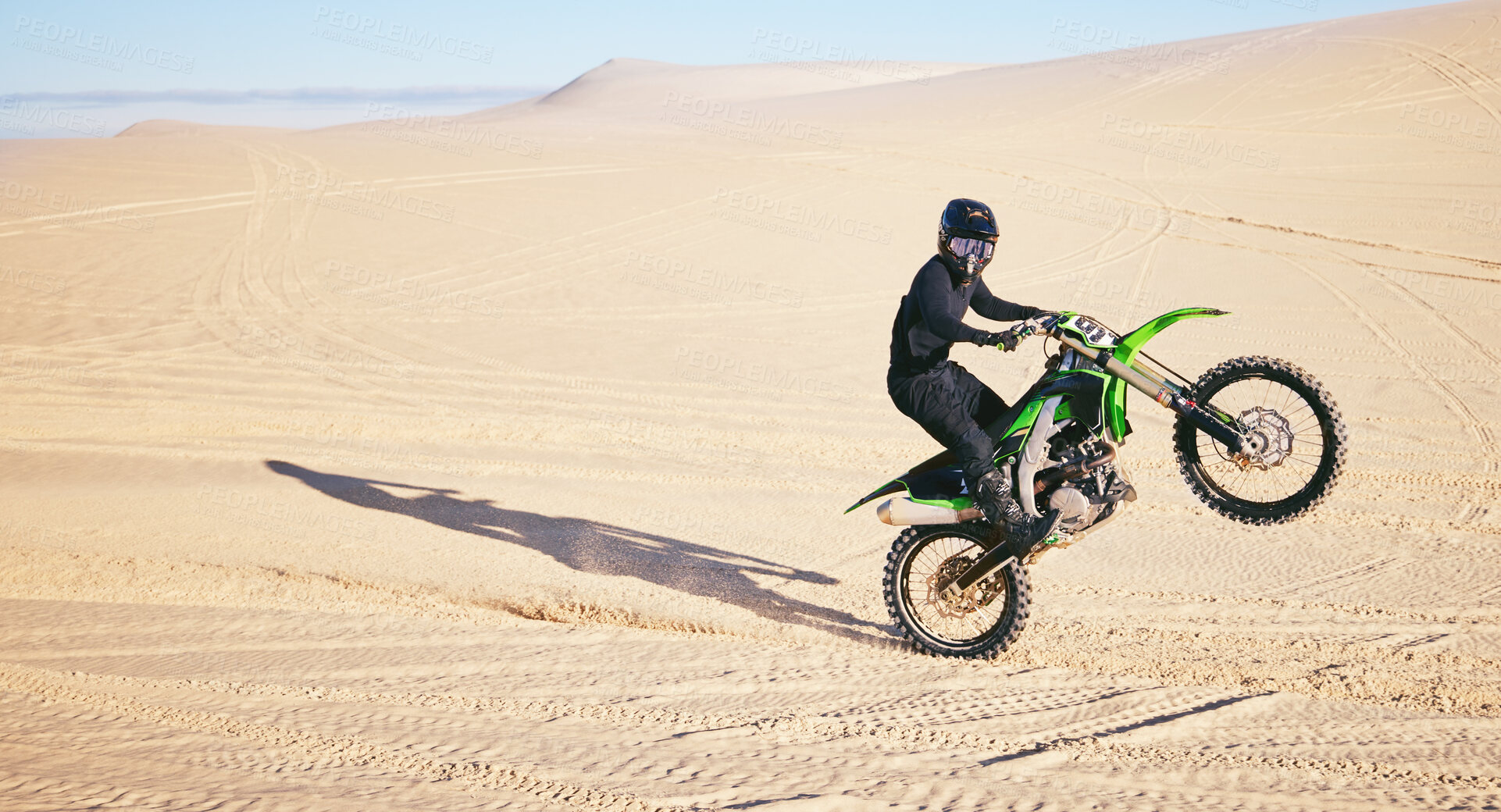 Buy stock photo Motorcycle, sand and space with a man in the desert for adrenaline, adventure or training in nature. Energy, summer and balance with an athlete riding a bike for sports training in a remote location
