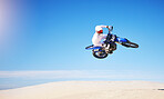Race, motorbike jump and person in desert, action and extreme sport with speed outdoor and mockup space. Adventure, fitness and blue sky, motorcycle jump stunt and freedom, challenge and performance