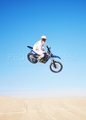 Buy stock photo Jump, motorbike and person in desert, blue sky with action and extreme sport, speed outdoor and mockup space. Adventure, fitness and motorcycle in air with stunt performance, freedom and challenge