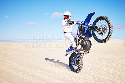 Buy stock photo Bike, freedom and balance with a man in the desert for fitness or an adrenaline hobby on a blue sky. Motorcycle, training and summer with a male sports athlete riding a vehicle in Dubai for energy