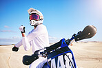Sports, cycling and man stretching on motorbike on sand for adrenaline, adventure and freedom in desert. Fitness, extreme action and male person on bike on dunes for training, exercise and challenge