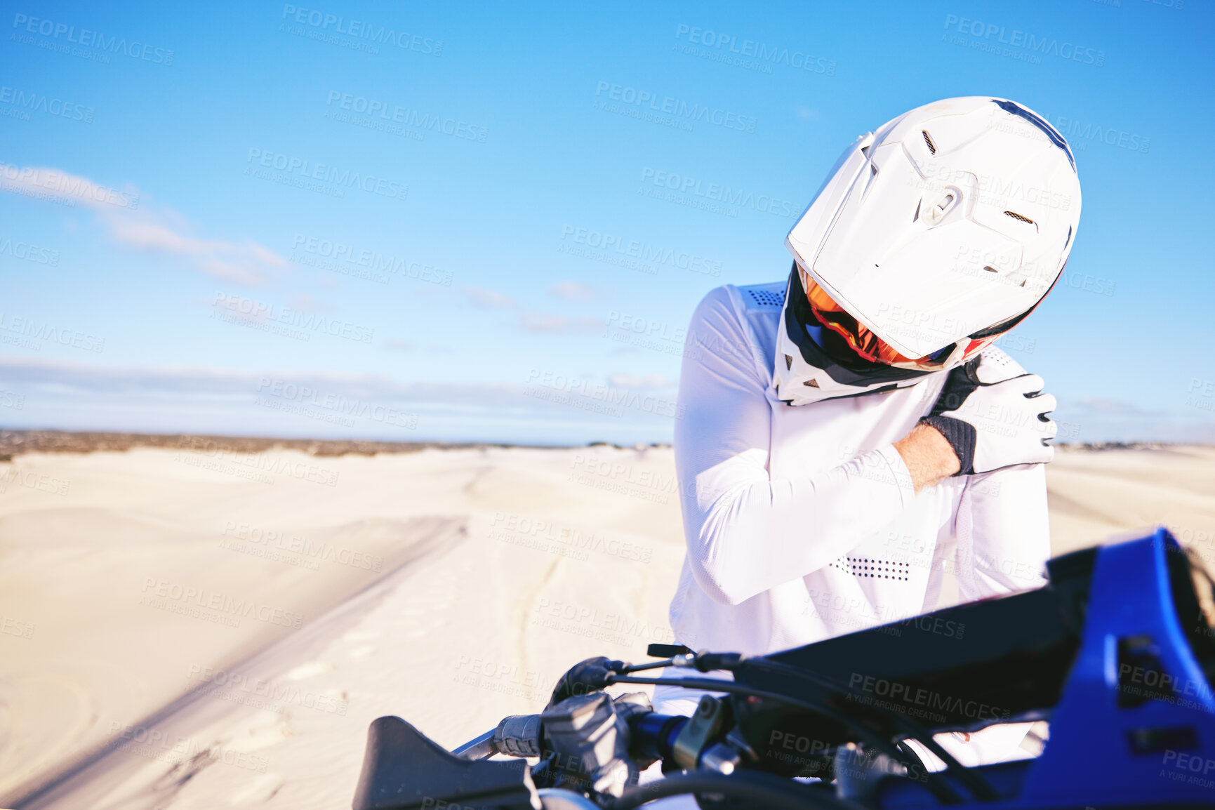 Buy stock photo Stretching, shoulder pain and person on motorbike with a strain or injury in desert ready for extreme sports. Performance, training and hurt rider in nature for exercise with motorcycle on dirt road