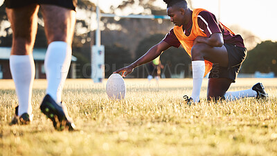 Buy stock photo Rugby ball, kick and sport game with holding support, exercise and competition with athlete training. Field, black man and target practice on grass with fitness and team workout outdoor for teamwork