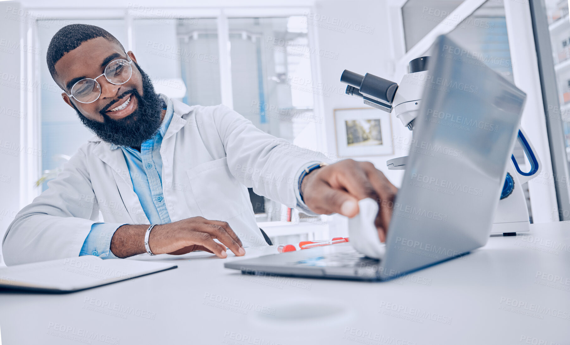 Buy stock photo Wiping keyboard, research and a scientist or man in a lab, working and disinfectant for a laptop. Happy, healthcare and a doctor or an employee cleaning a computer of a virus for medical safety