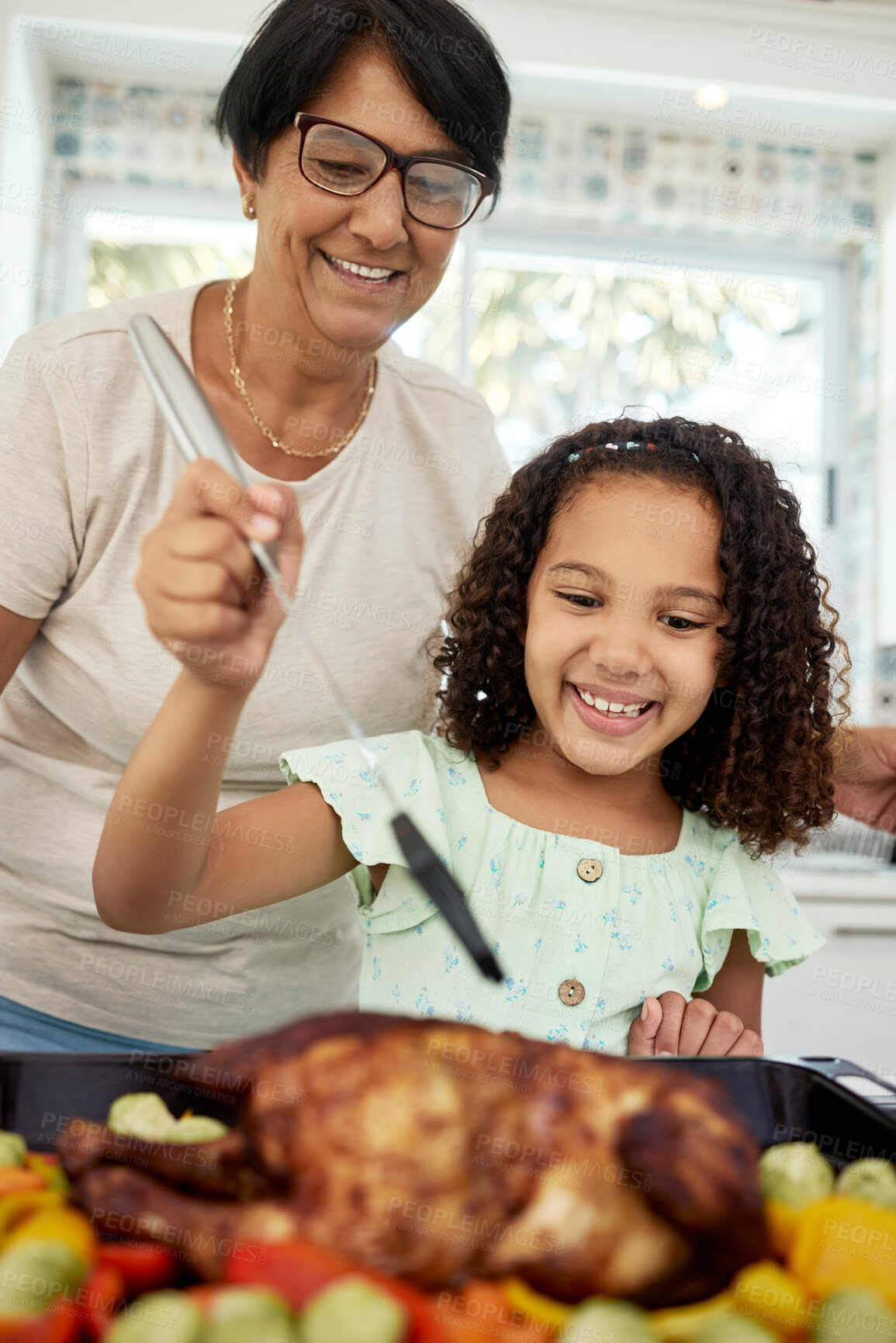 Buy stock photo Kitchen, food and a grandmother cooking with her grandchild in their home together for thanksgiving. Children, love and a roast with a senior woman preparing a meal with a girl for healthy nutrition