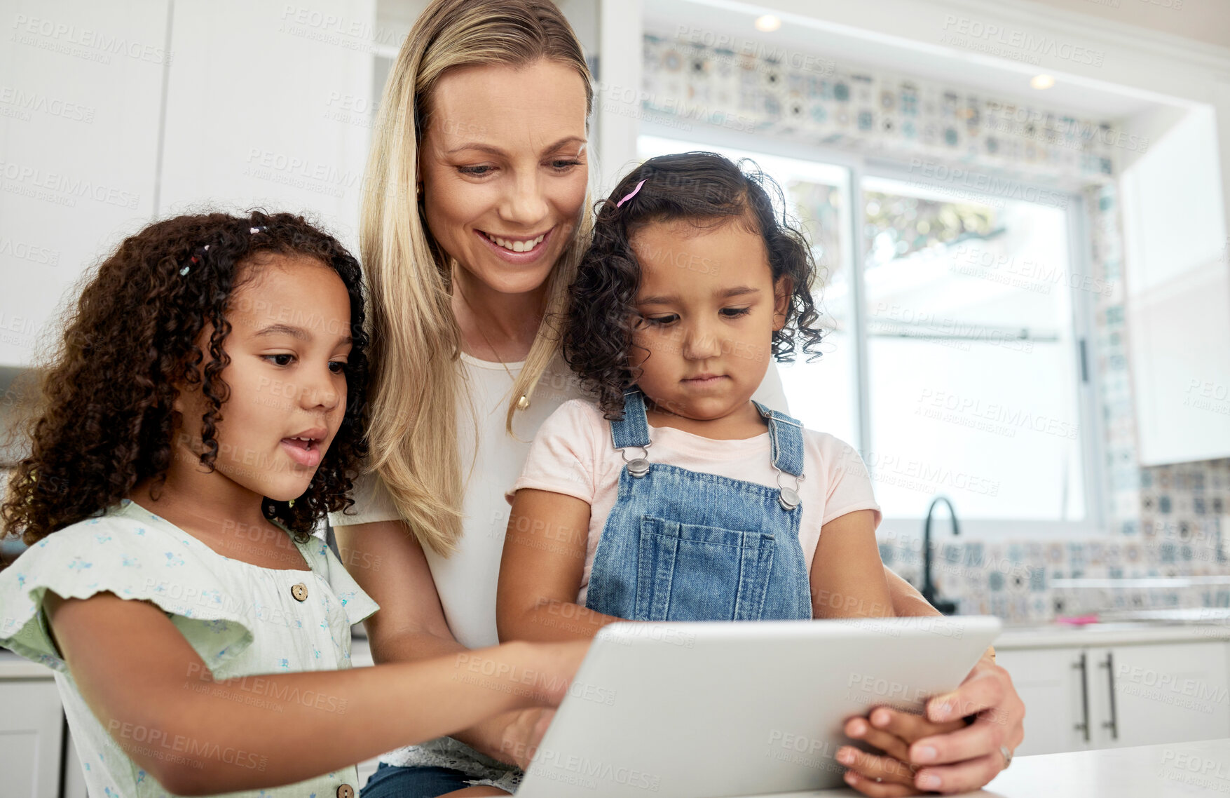 Buy stock photo Blended family, adoption and a mother with her kids on a tablet in the kitchen for education or learning. Sister, diversity and study with woman teaching her girl daughters in their home together