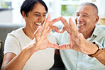 Mature couple, heart hands and love on home sofa for connection, marriage and bond. A happy man and woman together on a couch with emoji, shape or symbol for commitment, trust or health and wellness