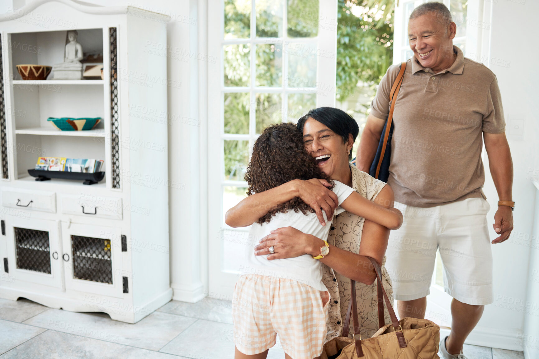 Buy stock photo Visit, home and girl hug grandparents by door excited for bonding, spending time and relationship. Family, happy and grandmother, grandfather and child embrace for greeting, welcome and arrival