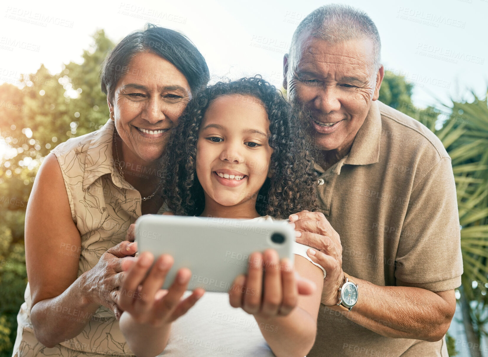 Buy stock photo Girl child, grandparents and selfie in garden, backyard or park with smile, hug and care for post on social media. Senior man, woman and female kid with photography, profile picture or memory on blog