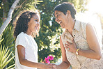 Flower gift, child or grandmother in park bonding together on mothers day with care, love or support. Kid, family or girl holding hands or giving a happy mature woman a floral present in retirement