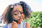 Girl child, magnifying glass and inspection in garden, backyard or park in science, study or outdoor. Young female kid, lens and zoom for nature, search or check for plant, leaves or growth in summer