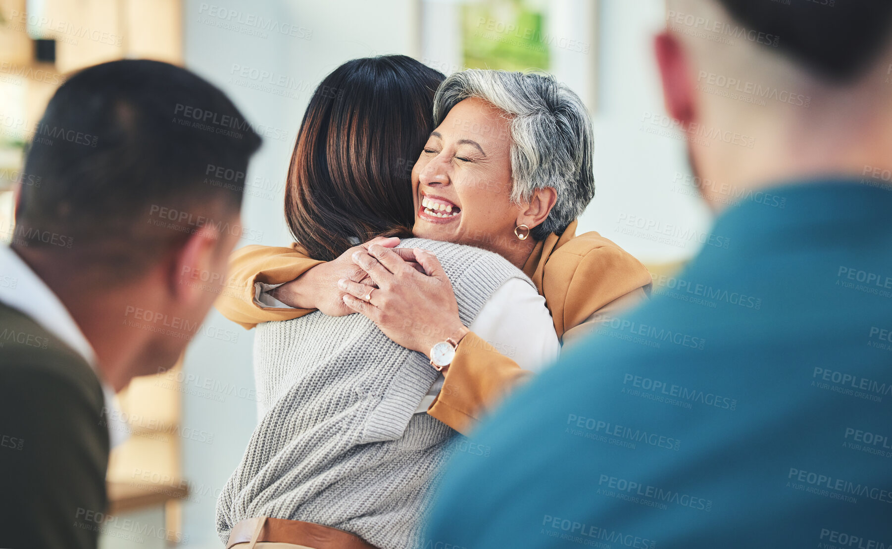 Buy stock photo Business people, women and hug in group therapy in office, care or bonding for mental health with smile. Corporate men, staff and colleagues with embrace for team building, welcome and happy together